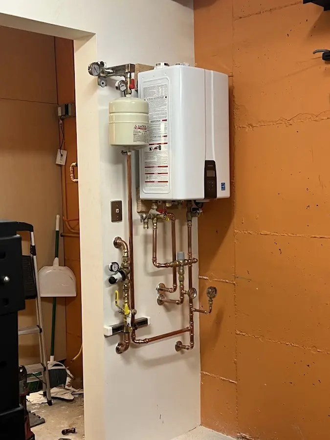 Plumbing technician inspecting water heater connections in Lino Lakes